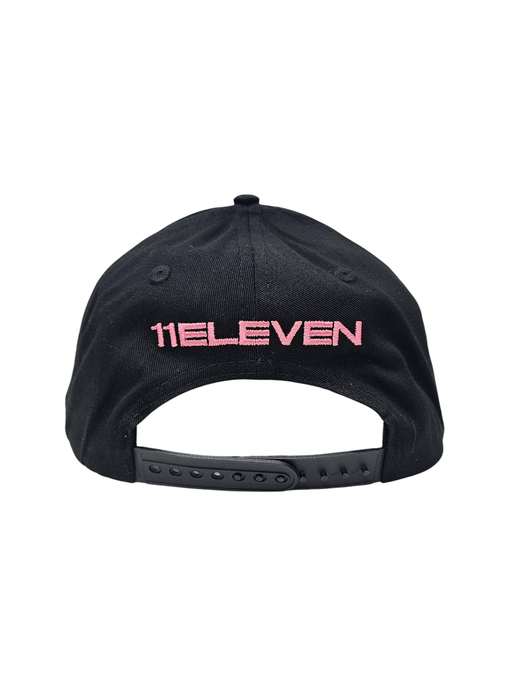 A back view of a black snapback baseball cap with hints of distressed texture and with embroidered pink 11.11 logo on a white backdrop. The cap also shows the adjustable snapback cap strap.