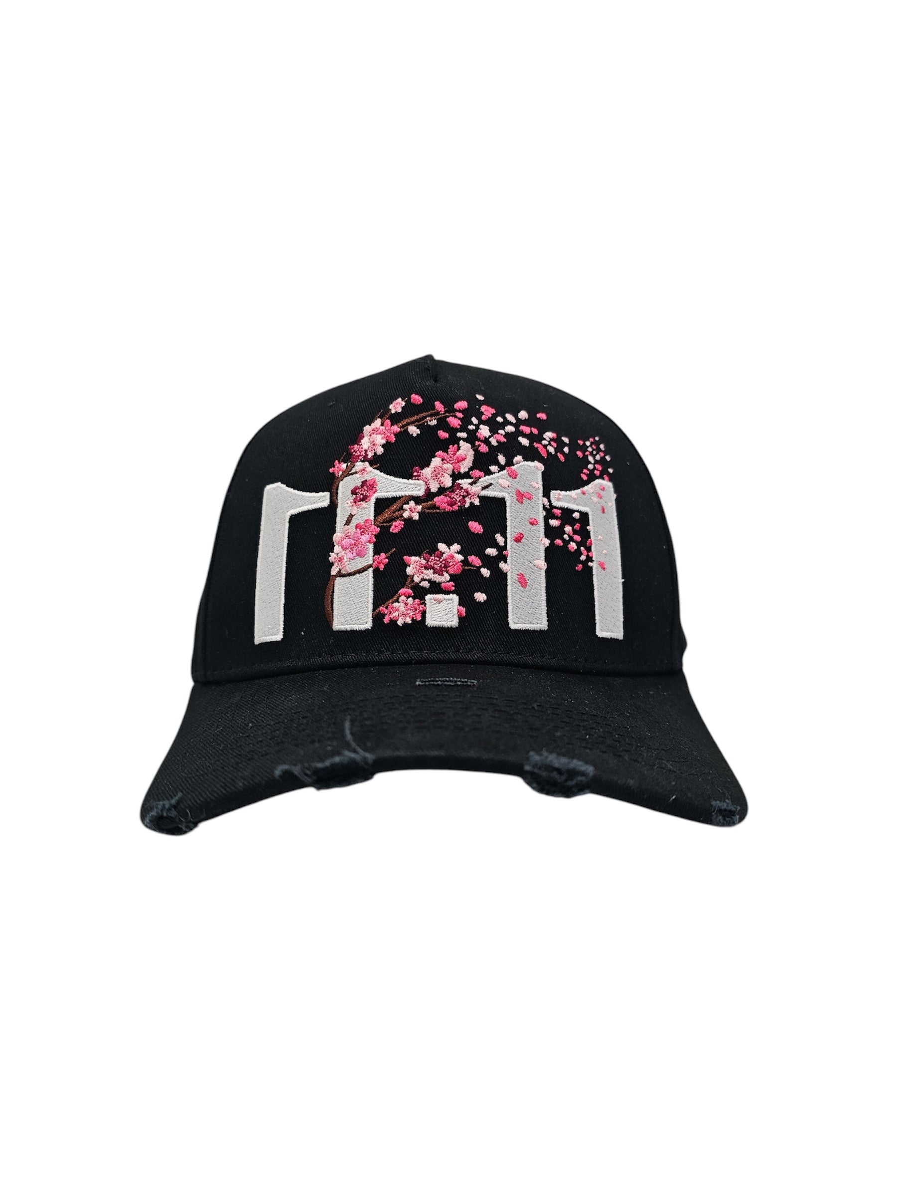 A front view of a black snapback baseball cap with hints of distressed texture and with embroidered pink floral blossom patterns between the 11.11 logo on a white backdrop.