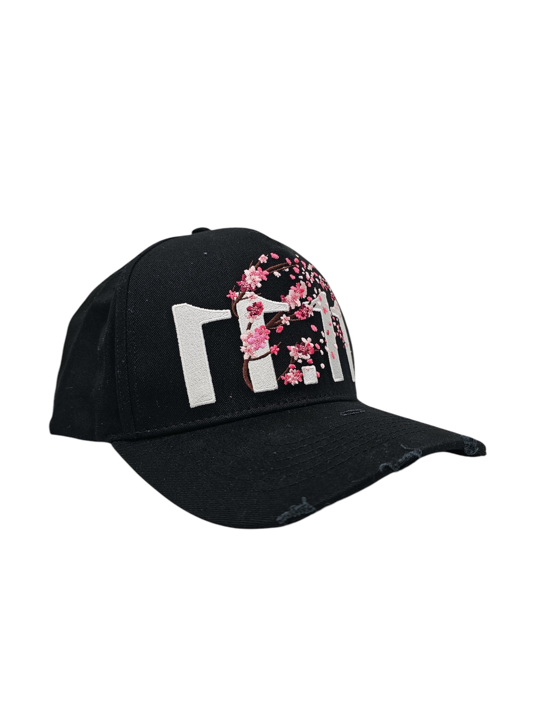 A left angled view of a black snapback baseball cap with hints of distressed texture and with embroidered pink floral blossom patterns between the 11.11 logo on a white backdrop.