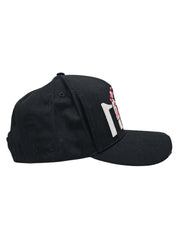 A left sided view of a black snapback baseball cap with hints of distressed texture and with embroidered pink floral blossom patterns between the 11.11 logo on a white backdrop.