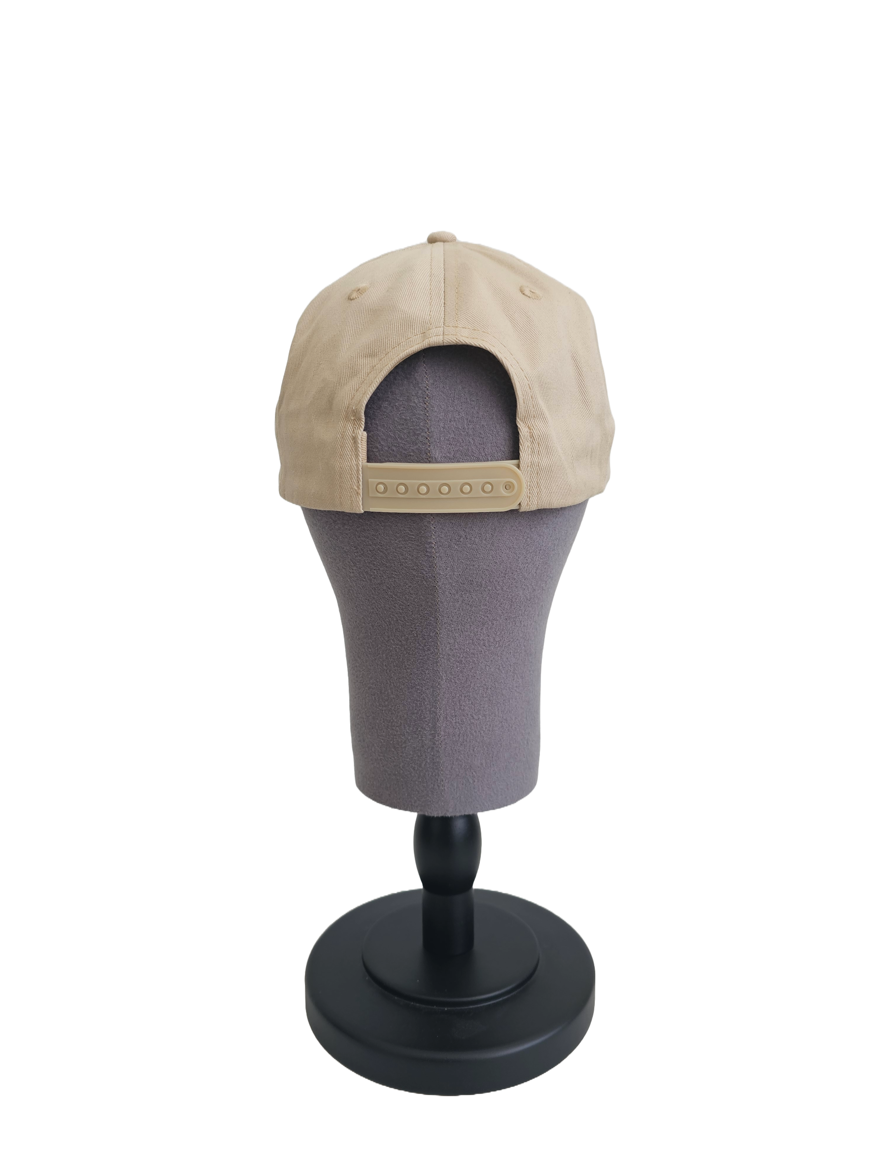 A back view of a beige snapback baseball cap on a mannequin head with a adjustable cap strap