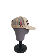 A left sided view of a beige snapback trucker cap on a mannequin head with an embroidered brown 11.11 number logo. The left side of the cap reveals the Broken Rose illustration on the trucker mesh cap