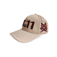 A right angled view of a beige snapback trucker cap with an embroidered brown 11.11 number logo. The right side of the cap reveals a brown embroidered 11ELEVEN symbol logo on the trucker mesh cap on a white backdrop.