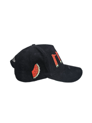 Side view of black corduroy snapback hat with embroidered 11:11 logo and watermelon slice in the shape of the Palestinian land, pro-Palestine streetwear cap symbolizing solidarity, featuring red, green, white, and black accents.