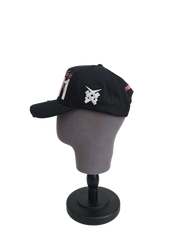 A right sided view of a black snapback baseball cap on a mannequin head with hints of distressed texture and with embroidered pink floral blossom patterns between the 11.11 logo on a white backdrop. The right side of the cap has a white embroided 11.11 symbol logo on it