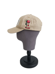 A right sided view of a beige snapback baseball cap on a mannequin head with an embroidered white 11.11 number logo, also revealing The Broken Roses Illustration on the right side of the cap