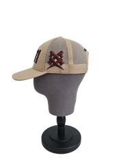 A right sided view of a beige snapback trucker cap on a mannequin head with an embroidered brown 11.11 number logo. The right side of the cap reveals a brown embroidered 11ELEVEN symbol logo on the trucker mesh cap
